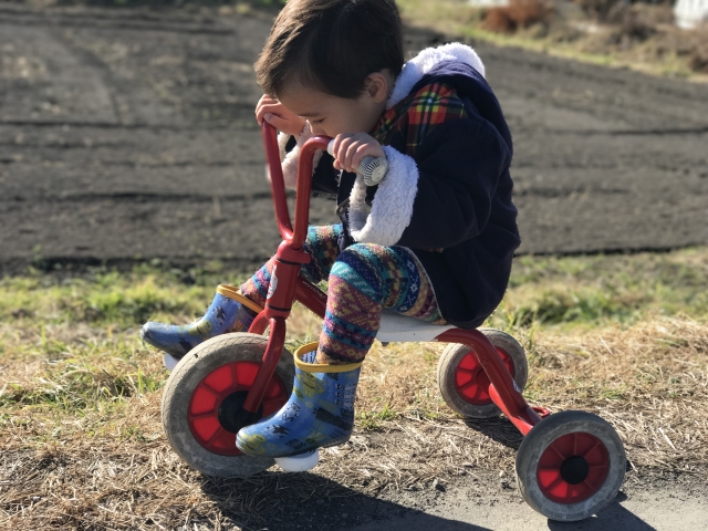 三輪車を漕ごうとする子ども